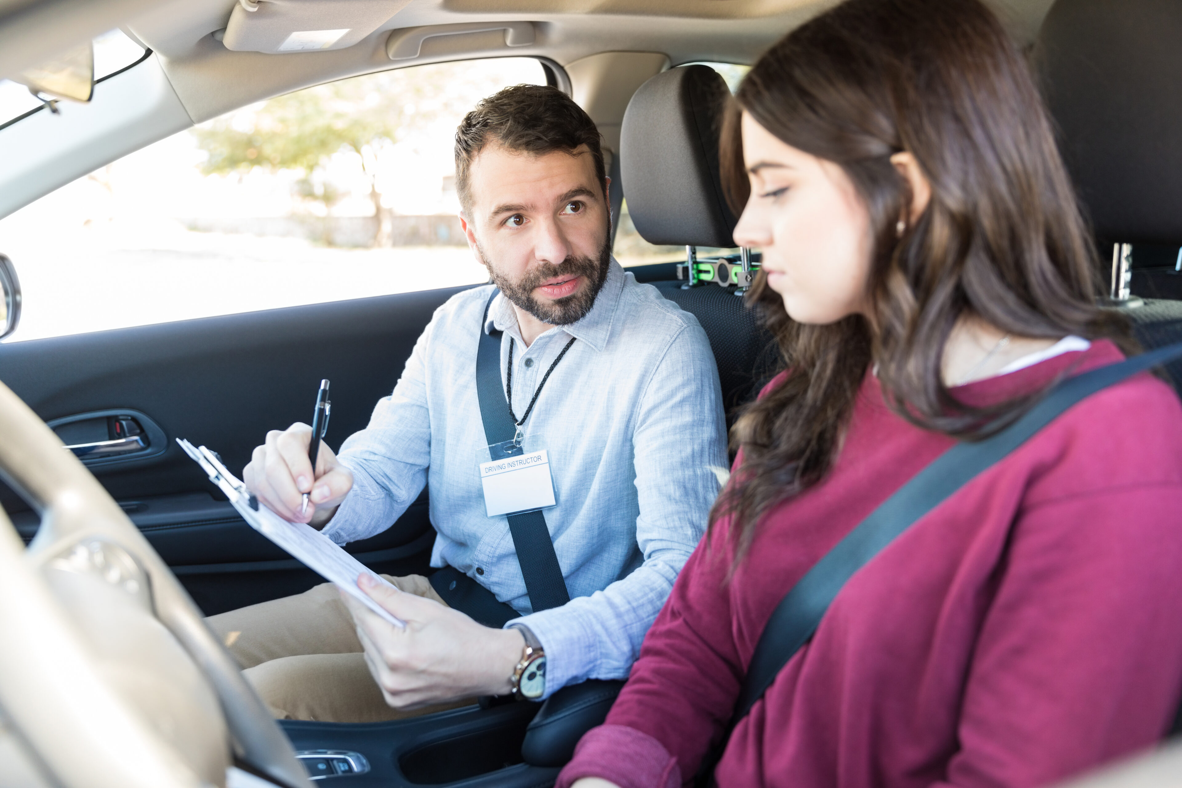 Driving instructor explaining checklist to learner driver