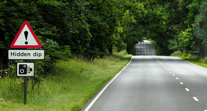 UK road sign warning of a hidden dip in the road.
